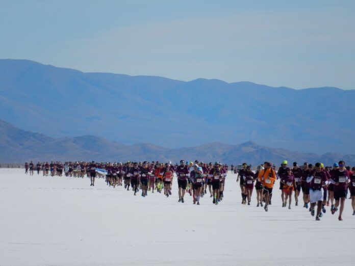 Corredores de trail running en Salinas Grandes, Jujuy, durante el Raid de los Andes con paisaje de altura.