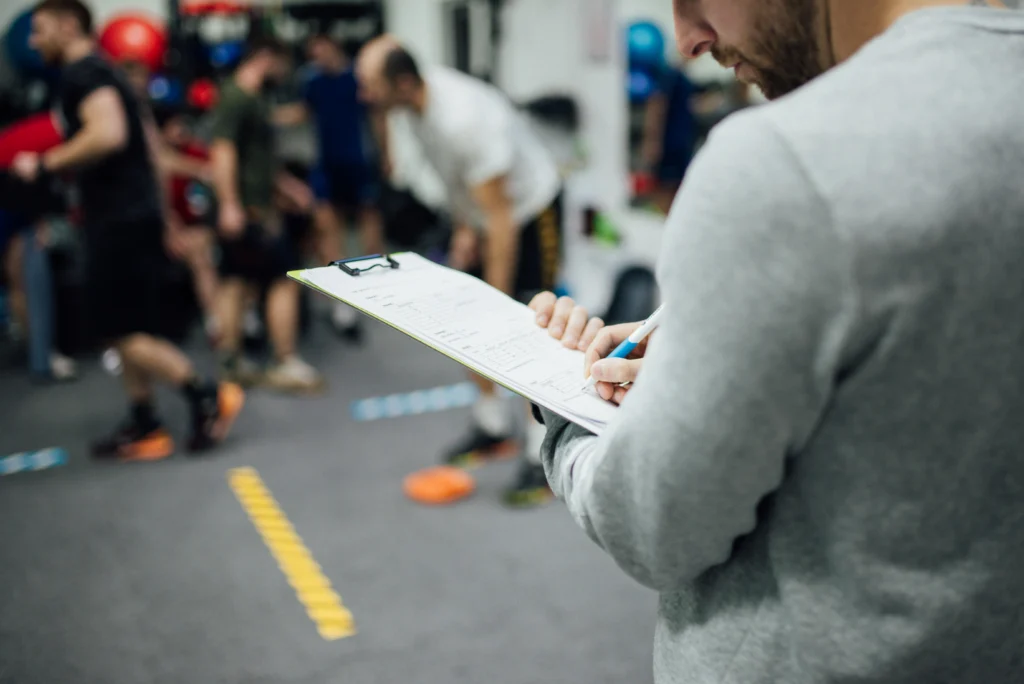 Entrenador observando una clase de boxeo en un gimnasio, imagen de archivo representativa de la práctica boxística
