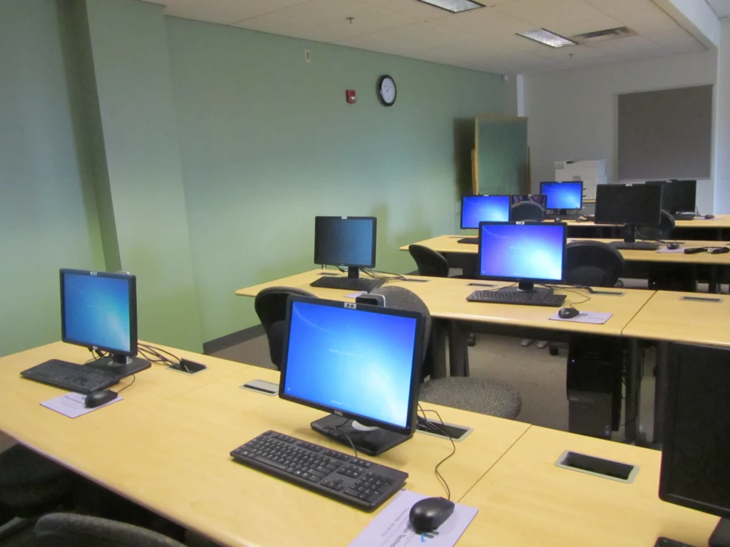 Aula universitaria con computadoras, imagen de archivo representativa de una comisión de cursado virtual