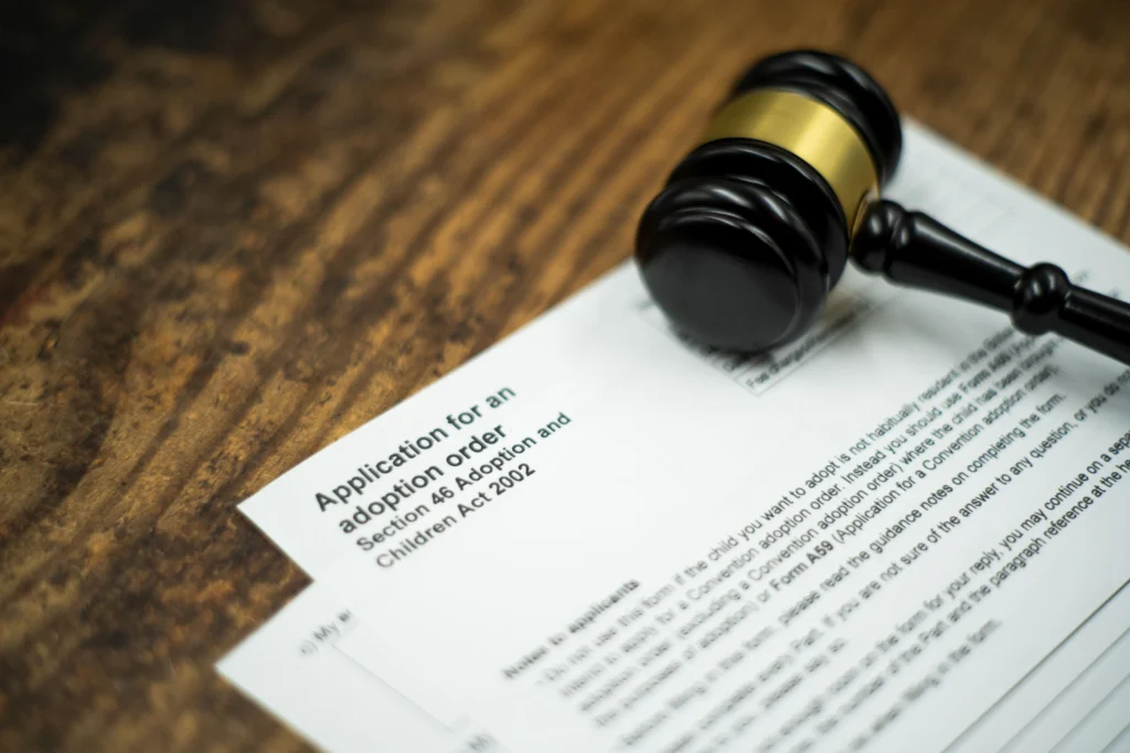 Formulario de solicitud de adopción junto a un mazo judicial, imagen de archivo representativa