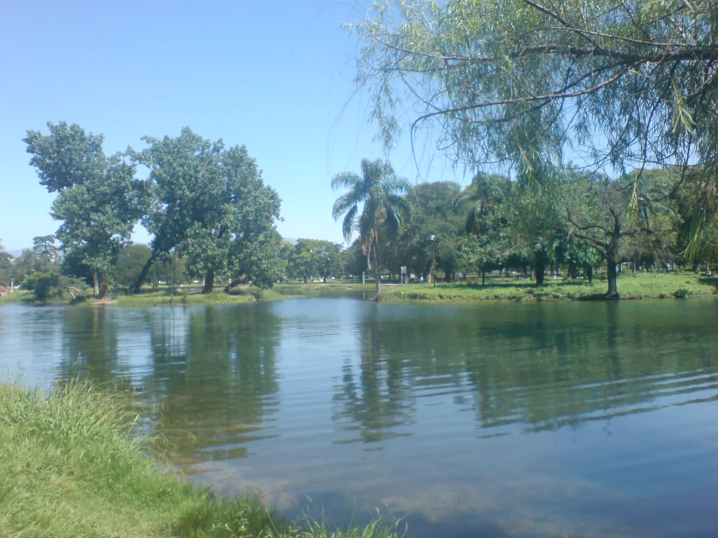 Vista del Lago San Miguel, en el Parque 9 de Julio de San Miguel de Tucumán, con agua y árboles a orillas.