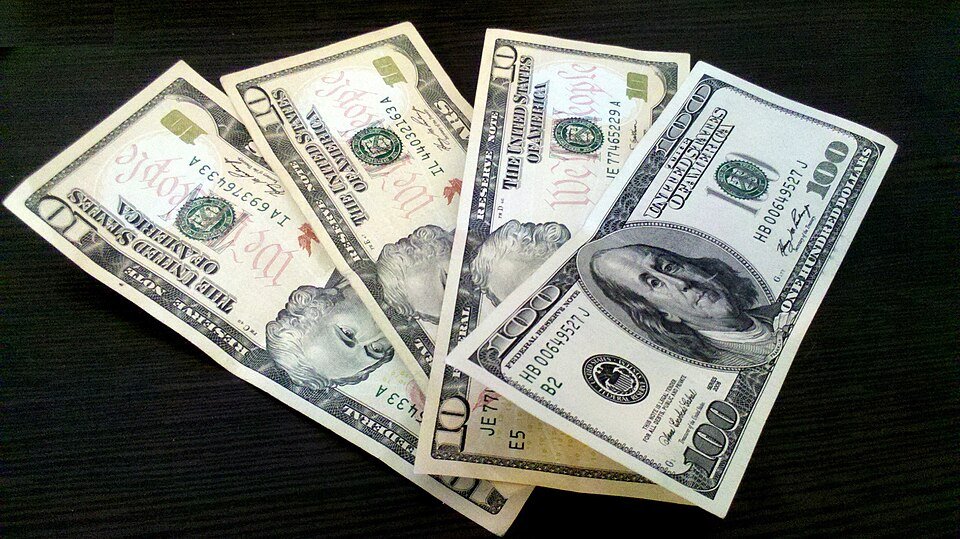 Billetes de dólares estadounidenses sobre una mesa. Fotografía ilustrativa, sin valores de cotización.