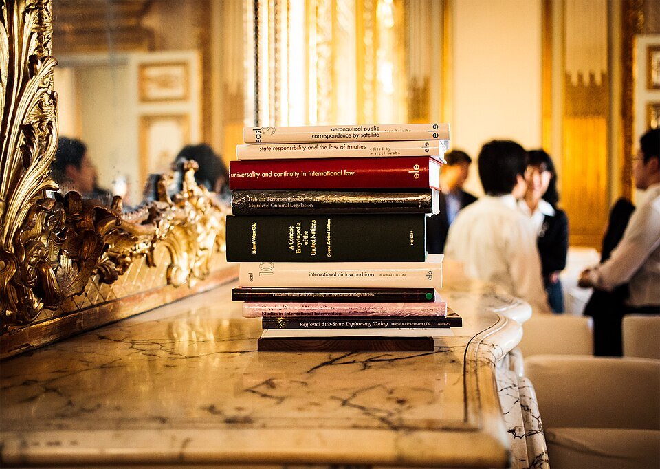 Libros de derecho apilados sobre una mesa. Fotografía ilustrativa del trabajo jurídico; no es una tabla de honorarios.